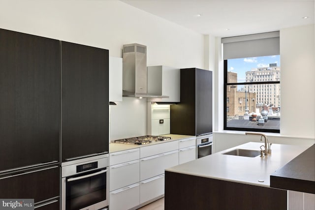 kitchen with a city view, a sink, light countertops, appliances with stainless steel finishes, and modern cabinets