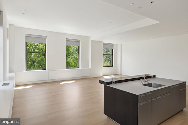 kitchen with a center island with sink, visible vents, open floor plan, a sink, and modern cabinets