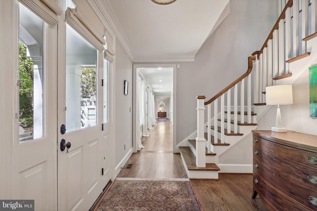 entryway with crown molding, a healthy amount of sunlight, and dark wood-type flooring