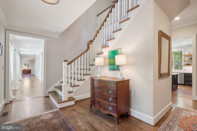 stairs featuring ornamental molding and hardwood / wood-style floors