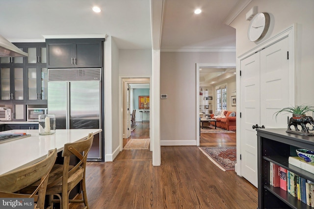 kitchen featuring crown molding, dark hardwood / wood-style floors, and built in fridge