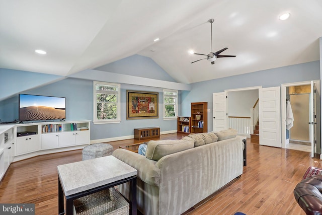 living room with ceiling fan, lofted ceiling, and light hardwood / wood-style floors