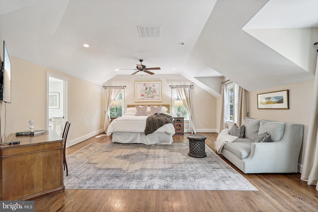 bedroom with multiple windows, lofted ceiling, ceiling fan, and light hardwood / wood-style floors