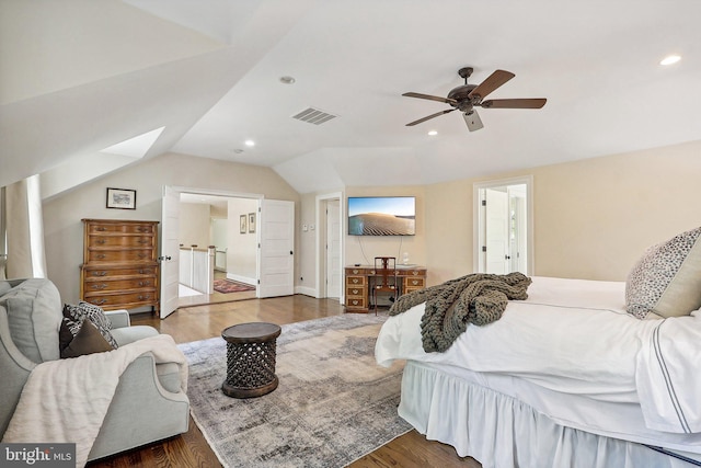 bedroom with dark wood-type flooring, vaulted ceiling, ensuite bath, and ceiling fan