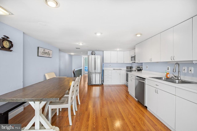 kitchen featuring white cabinets, light hardwood / wood-style flooring, sink, and stainless steel appliances