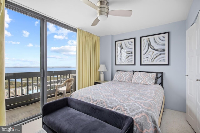 bedroom with a water view, ceiling fan, and carpet flooring