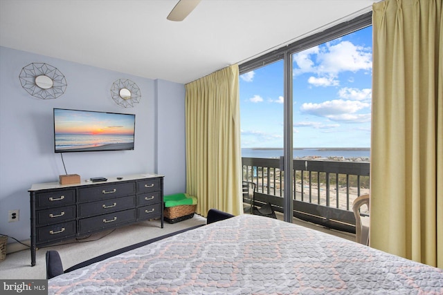 bedroom with light carpet, ceiling fan, a water view, and access to exterior