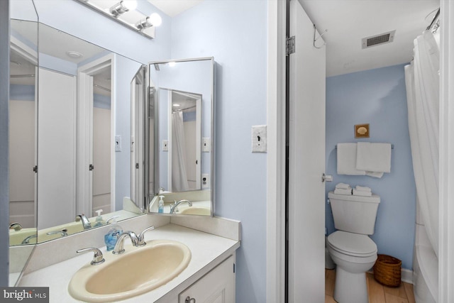 bathroom with wood-type flooring, vanity, and toilet