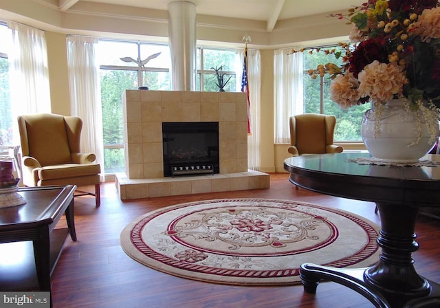 sitting room featuring beam ceiling, a fireplace, and hardwood / wood-style flooring