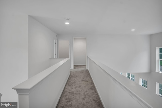 hall with baseboards, recessed lighting, an upstairs landing, and light colored carpet