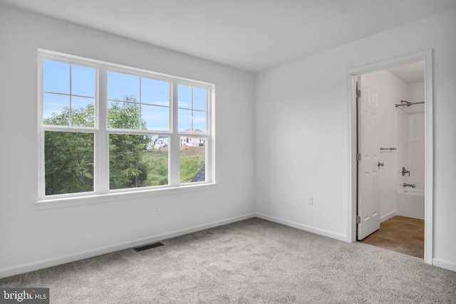 unfurnished bedroom featuring baseboards, visible vents, and light colored carpet