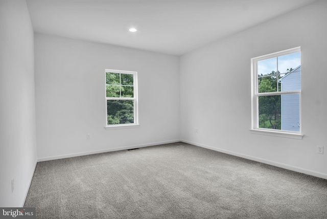 unfurnished room with recessed lighting, carpet flooring, visible vents, and baseboards