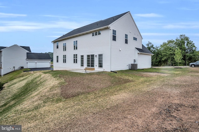 rear view of house featuring a garage, a patio area, central AC unit, and a lawn