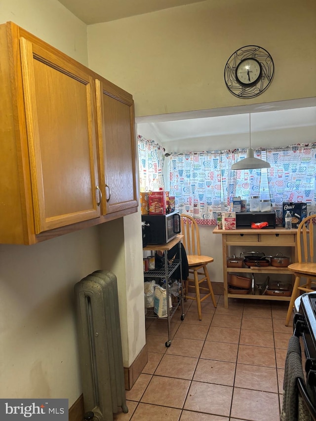 kitchen featuring light tile patterned floors and radiator