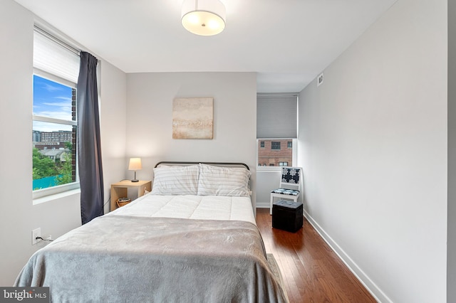 bedroom with dark hardwood / wood-style flooring