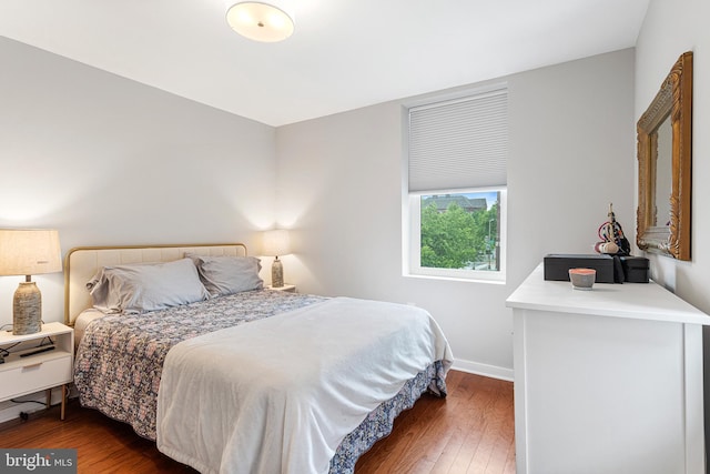 bedroom with dark hardwood / wood-style flooring