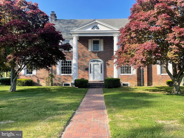 neoclassical home featuring a front yard