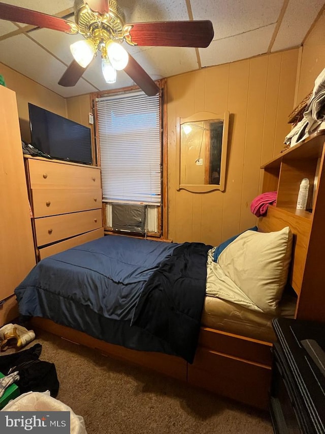 carpeted bedroom featuring a drop ceiling and ceiling fan