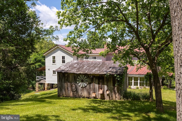 rear view of property featuring a lawn