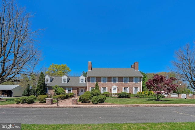 colonial inspired home with a front lawn