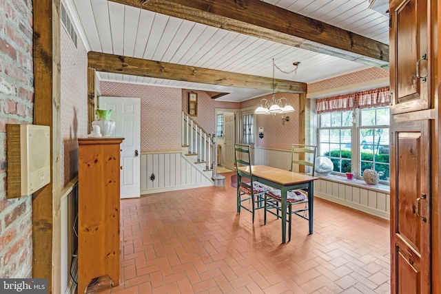 dining space with beamed ceiling and an inviting chandelier