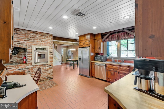 kitchen with wooden ceiling, brick wall, sink, and stainless steel appliances