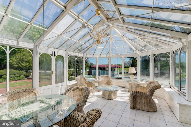 sunroom featuring vaulted ceiling and a notable chandelier