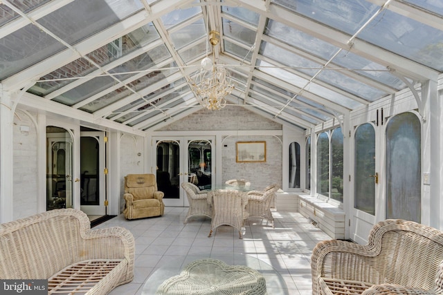 sunroom with french doors, vaulted ceiling, and an inviting chandelier