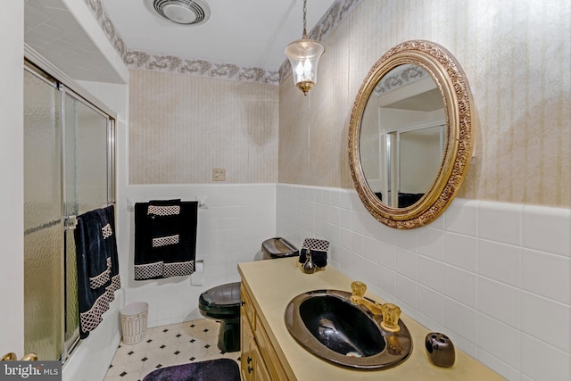 bathroom featuring tile walls, backsplash, toilet, and vanity with extensive cabinet space