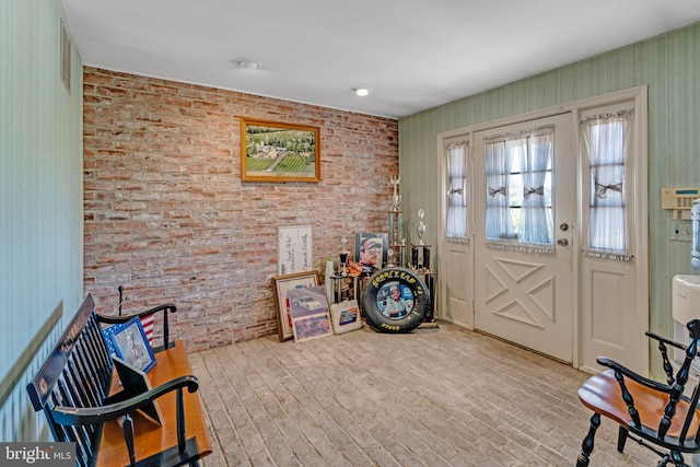 entrance foyer featuring brick wall