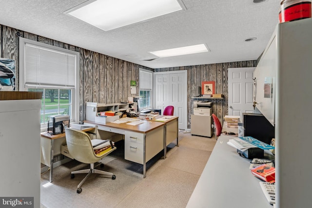 carpeted office with wood walls and a textured ceiling