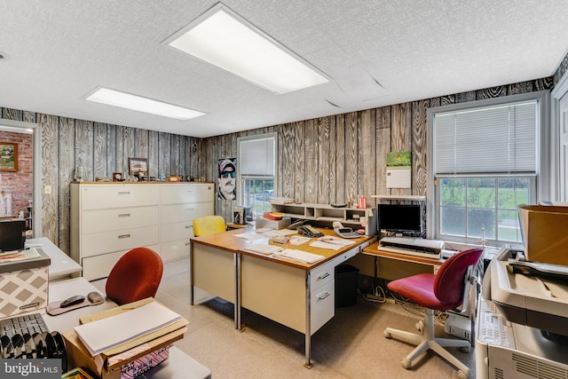 office area with a textured ceiling and wood walls