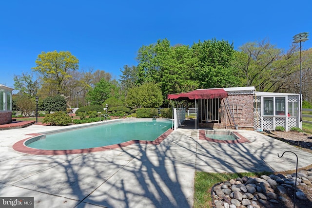 view of pool with a sunroom and a patio area