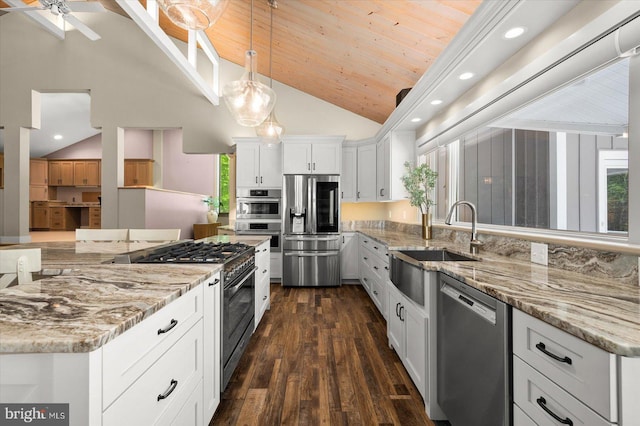 kitchen with decorative light fixtures, white cabinets, dark hardwood / wood-style flooring, stainless steel appliances, and ceiling fan