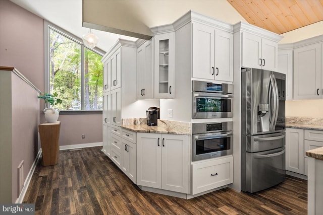 kitchen with appliances with stainless steel finishes, dark hardwood / wood-style flooring, and white cabinets