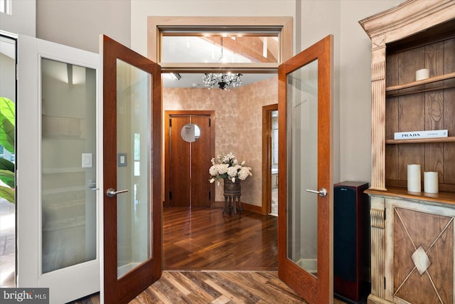 foyer featuring french doors, an inviting chandelier, and dark hardwood / wood-style flooring