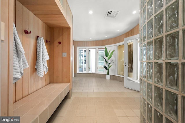 mudroom with french doors, wooden walls, and light tile floors