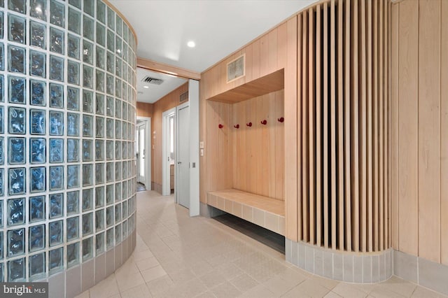 mudroom featuring tile flooring and wood walls