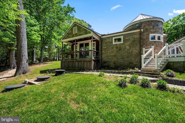 rear view of property with a deck and a lawn