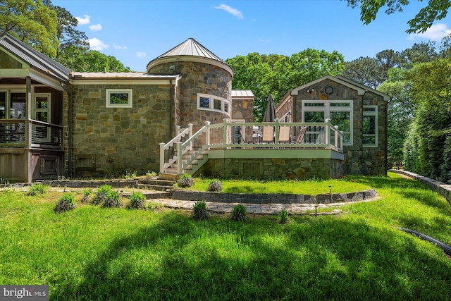 back of house with a deck and a lawn