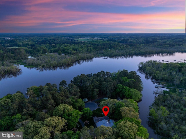 aerial view at dusk featuring a water view