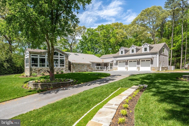 cape cod house featuring a garage and a front lawn