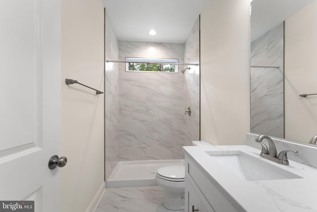 bathroom featuring vanity, toilet, and tiled shower