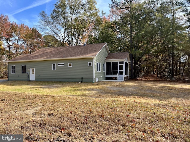 back of property featuring a sunroom and a yard