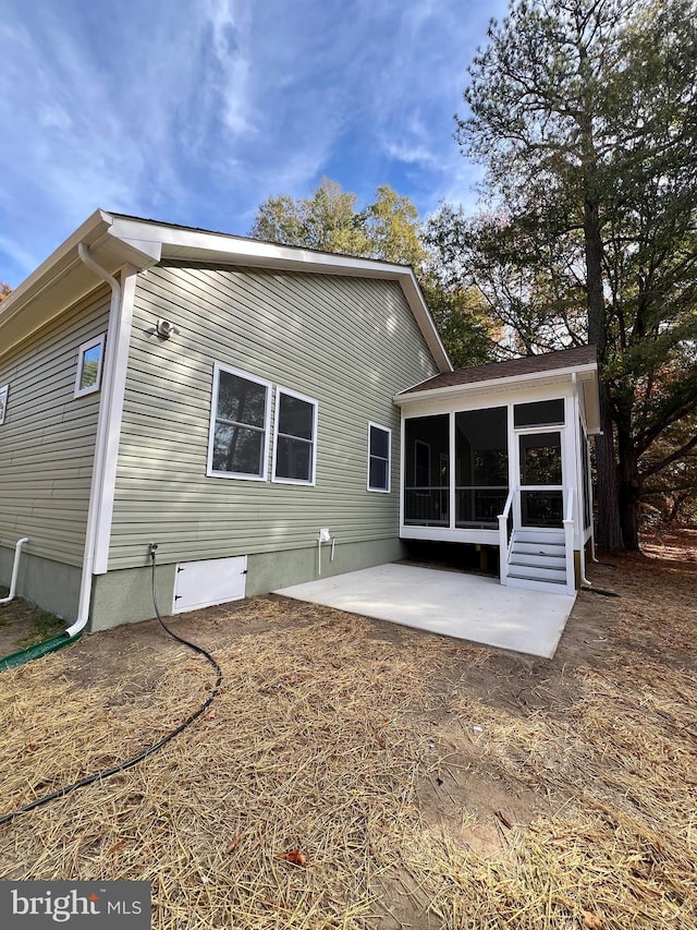 rear view of property featuring a sunroom and a patio