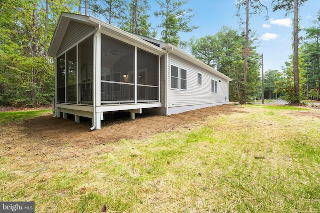 view of side of home featuring a sunroom and a yard