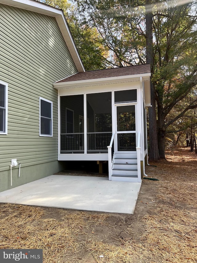 back of property with a patio area and a sunroom