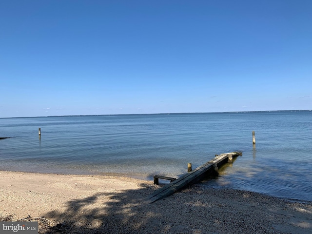 dock area with a water view and a view of the beach