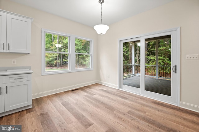 unfurnished dining area featuring light hardwood / wood-style flooring