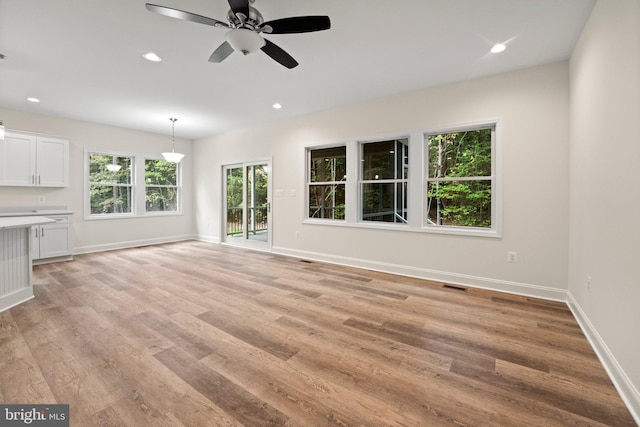 unfurnished living room with light hardwood / wood-style flooring and ceiling fan